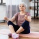 A senior woman practices mindfulness while sitting on a yoga mat. 