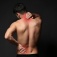 A person rubs their neck and lower back, concept of chronic pain. 