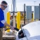 A University at Buffalo employee plugging a charger into an electric vehicle. 