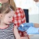 A young child about to receive a vaccination shot from a medical professional. 