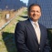 Amit Goyal standing in front of a solar farm. 