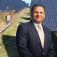 Amit Goyal stands before an array of solar panels. 