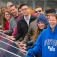 Students placing their hands on a solar panel at UB's Solar Strand. 