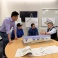 Three students at a table explaining their design model for a manufactured home. 