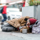 Homeless person sleeping on a sidewalk. 