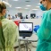 faculty member and student look at a scan of a tooth on a computer model. 
