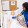nursing student uses a stethoscope to listen to the heart of a mannequin. 