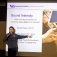 Benedikt Harrer points to a large screen depicting a person playing a brass instrument during his Physics of Sound class. 