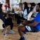 Students in conversation sitting around a table. 