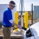 A person charges an electric vehicle at a charging station. 