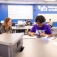 Thre high school students seated at a table happily working together. 