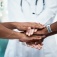Closeup of medical workers with their hands stacked on top of each other, concept of support, motivation between medical doctor and healthcare workers. 