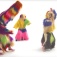 Still from video, "Nick Cave's Soundsuits" featuring dancers in colorful, shaggy full-body costumes. 