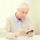 Older woman looking at a blood sugar monitor. 