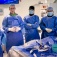 Elad Levy and his surgical team wearing surgical garb in the operating room. 