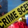 Concept of urban gun violence featuring an urban setting in the background, a "crime scene" tape in the foreground . 