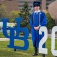 Michael Reyf pictured next to a sign reading "UB 2026" located near the bronze buffalo in front of the Center for the Arts on UB's North Campus. 