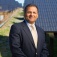 Amit Goyal poses in front of a solar panel at the solar strand. 