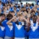 First-year students wearing shirts with the UB Spirit Mark give the horns up sign as the line up to form the human interlocking UB. 