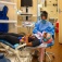 A dental student flosses the teeth of a patient as part of an exam and cleaning. 